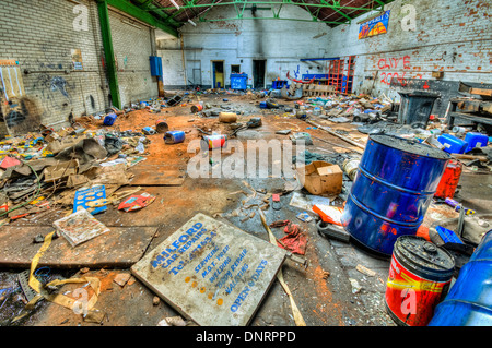 Öl-Trommeln und Kanister über einer verlassenen Garage geworfen Stockfoto