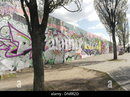 Schrägansicht von Pappeln vor der inneren Mauer bedeckt Graffiti Gekritzel, Mauerpark, Berlin Stockfoto