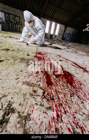 Szene des Verbrechens Officer (SOCO) untersucht eine Gegend um etwas Blut auf dem Boden [industrieübergreifend Modell] Stockfoto