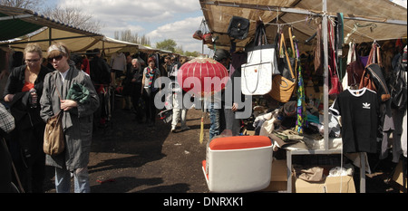 Sonnige Aussicht Passanten vorbei an roten Chines Laterne hängenden stall Verkauf Taschen, Kleider Hemden, Mauerpark Flohmarkt, Berlin Stockfoto