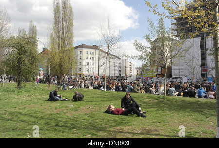 Sonnigen Sonntag Blick auf Oderberger Straße Wohnungen, Menschen liegen Mauerpark Rasen, viele zu Fuß, sitzen Bernauer Straße, Berlin Stockfoto