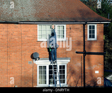 Ein Mann auf einer Leiter Fensterputzen England uk Stockfoto