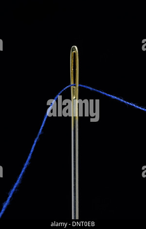 Nahaufnahme eines blauen Faden durch das Auge eines Nähnadel Stockfoto