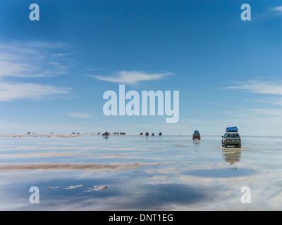 Touristen und Allrad-Fahrzeuge zu stoppen, sich zu beteiligen, das außergewöhnliche Zusammenspiel von Reflexionen aus dem Wasser am Salar de Uyuni. Stockfoto