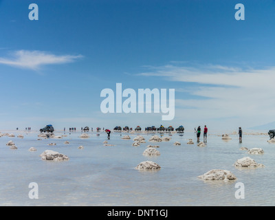 Touristen und Allrad-Fahrzeuge zu stoppen, sich zu beteiligen, das außergewöhnliche Zusammenspiel von Reflexionen aus dem Wasser am Salar de Uyuni. Stockfoto