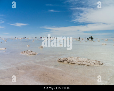 Touristen und Allrad-Fahrzeuge zu stoppen, sich zu beteiligen, das außergewöhnliche Zusammenspiel von Reflexionen aus dem Wasser am Salar de Uyuni. Stockfoto