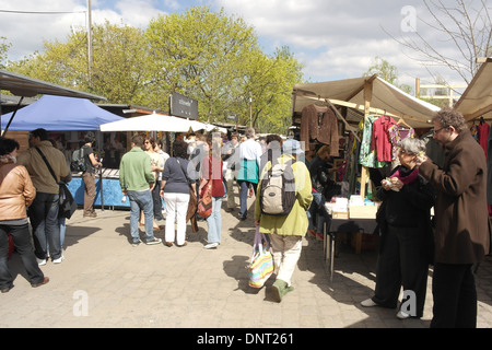 Sonnige Aussicht, Schonwetter Club, Mann Frau Essen Sandwiches, Menschen zu Fuß vorbei an Kleidung Stall, Mauerpark Flohmarkt, Berlin Stockfoto