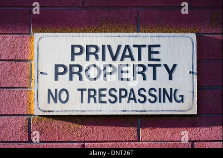 Verblichene Zeichen auf Brick Wand "Private Property No überzutreten" Stockfoto