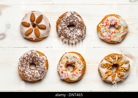 Sechs bunte Donuts auf alten Holztisch Stockfoto