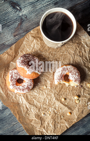 Heißer Kaffee und Donuts in das Papier gegeben Stockfoto