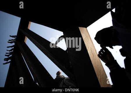 Tel Aviv, Israel. 5. Januar 2014. Afrikanische Asylbewerber sitzen auf einer Holocaust-Mahnmal-Installation auf Rabin-Platz während eines Streiks in Tel Aviv, Israel, am 5. Januar 2014. Fordern ihre Freiheit, streikten Zehntausende von afrikanischen Asylsuchenden und ihre Unterstützer in Israel am Sonntag eine dreitägige in Tel Avivs Hauptplatz. Einige 50.000 afrikanische Asylbewerber und Flüchtlinge leben in Israel. Die meisten von ihnen flohen Eritreas Verfolgungen und gezwungen, Wehrpflicht oder Konflikte im Sudan. Bildnachweis: JINI/Daniel Bar auf/Xinhua/Alamy Live-Nachrichten Stockfoto