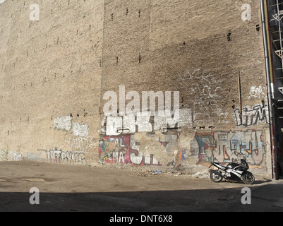 Sonnige Aussicht leistungsstarken Motorrad in Erde Parkplatz unterhalb der hohen breiten Graffiti Gekrakel Gebäude Wand, Greifswalder Straße, Berlin Stockfoto