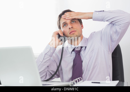 Besorgt Geschäftsmann auf Anruf an der Rezeption Stockfoto