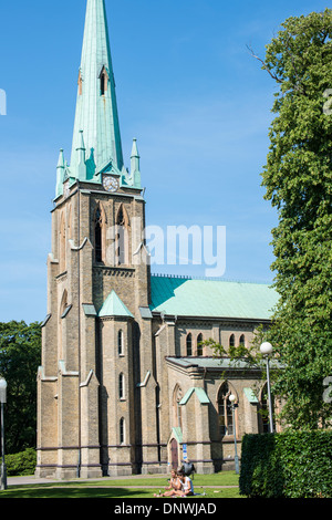 Menschen genießen die Sonne auf dem Gelände der Kirche Haga, Göteborg Stockfoto