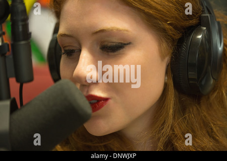 Hübsche Rothaarige Studentin hosting einer Radio-show Stockfoto