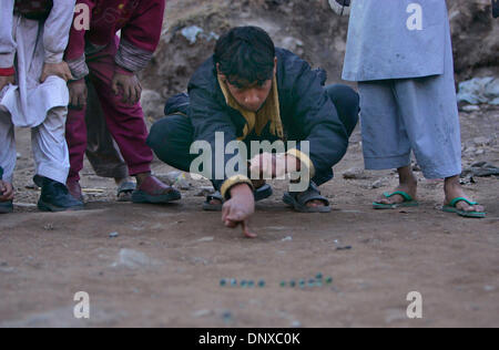 5. Dezember 2005; Balakot, PAKISTAN; Nachwirkungen des Erdbebens in Pakistan am 8. Oktober 2005. Kleine Jungs spielen auf einem der Notfall Campingplätze in Balakot, Pakistan ein Kinder Spiel mit Murmeln. Obligatorische Credit: Foto von Nelvin Cepeda/San Diego Union T/ZUMA Press. (©) Copyright 2005 von San Diego Union T Stockfoto