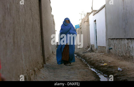 11. Dezember 2005; Kobul, AFGHANISTAN; Eine Frau macht ihren Weg nach unten einen Abschnitt des Weges, dass die Regierung nicht die Pflasterung mit Beton abgeschlossen hat. Das bevölkert allgemein Bereich bekannt als Dasht-e-Barchi in West Kobul sehr wenig Zeichen des Wiederaufbaus. Obligatorische Credit: Foto von Nelvin Cepeda/San Diego Union T/ZUMA Press. (©) Copyright 2005 von San Diego Union T Stockfoto