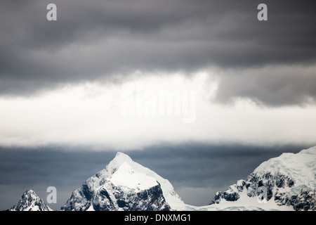 Eisbedeckte Insel Englische Straße Antarktische Halbinsel // Dunkle Wolken schweben über einer eisbedeckten Insel in der Englischen Straße auf der nördlichen Antarktischen Halbinsel. Stockfoto