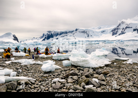 Antarktis - eine Gruppe von kajakfahrer an Land unter den Felsen und Eis bei Cuverville Insel an der Westküste der Antarktischen Halbinsel. Stockfoto
