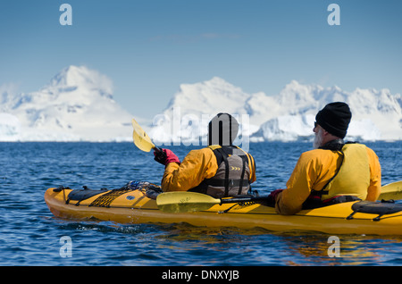 Antarktis - Kajakfahrer bewundern Sie die eindrucksvolle Landschaft auf einer klaren sonnigen Tag an Cuverville Island auf der Antarktischen Halbinsel. Stockfoto