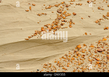 Sanddüne unter erodierten Bentonit bluff mit orange Deckstein Kieselsteinen, Theodore Roosevelt NP (South Unit), North Dakota, USA Stockfoto