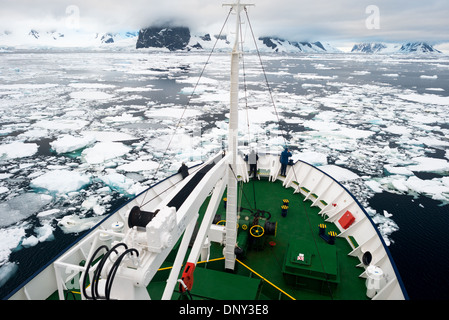 Antarktis - Ein Eis gestärkt Schiff gleitet durch das Meereis am nördlichen Ende des Lemaire Kanals entlang der Antarktischen Halbinsel. Stockfoto