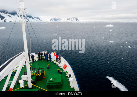 Antarktis - Passagiere zeichnen sich auf dem Bug eines Kreuzfahrtschiffes der Ansicht, wenn die durch den Lemaire Kanal, manchmal als 'Kodak' für seine malerische Ansichten bekannt zu bewundern. Stockfoto