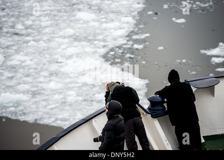 Antarktis - Fahrgäste stehen auf dem Bug eines ice-gestärkt Antarktis Kreuzfahrt Schiff wie Sie navigiert die engen Lemaire Kanal auf der westlichen Seite der Antarktischen Halbinsel. Die Lemaire Kanal wird manchmal auch als "Kodak Lücke' in einem Kopfnicken zu seiner berühmt malerische Aussicht bezeichnet. Stockfoto