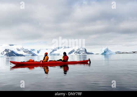 Antarktis - Kajakfahrer in einem Tandem kayak über spiegelglatte Wasser bei Petermann Island auf der Antarktischen Halbinsel gleiten. Stockfoto