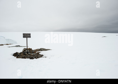 Britisches Kronland-Schild isoliert Schnee Winterinsel Antarktis | WINTERINSEL, Antarktis — Das "Britische Kronland"-Schild steht isoliert auf einer schneebedeckten Fläche der Winterinsel, ein Gletscherhanger ist dahinter sichtbar, in der Nähe des Wordie House (Base F). Aufgestellt vor dem Antarktis-Vertrag von 1961, der die sich überschneidenden Souveränitätsansprüche Großbritanniens, Argentiniens und Chiles auf der Halbinsel einfror, ist das Schild nun innerhalb des Historischen Ortes und Denkmals Nr. 62 geschützt, das vom UK Antarctic Heritage Trust erhalten wird. Stockfoto