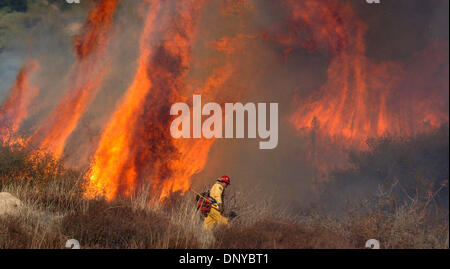 23. Januar 2006; San Bernardino, Kalifornien, USA; Hoch aufragenden Flammen durch starke Winde gepeitscht droht einen Feuerwehrmann im San Bernardino National Forest in der Nähe von Highland, Kalifornien, auf Montag, 23. Januar 2006.  Eine verdächtige Glut angefacht von einem Santa Ana Wind Ereignis hält Feuerwehr beschäftigt.   Obligatorische Credit: Foto von Steven K. Doi/ZUMA Press. (©) Copyright 2006 von Steven K. Doi Stockfoto