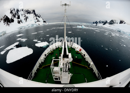 Antarktis - Ein Eis gestärkt Schiff treibt durch verstreute Platten von Meereis im ruhigen Wasser in der Lemaire Kanal auf der westlichen Seite der Antarktischen Halbinsel. Stockfoto