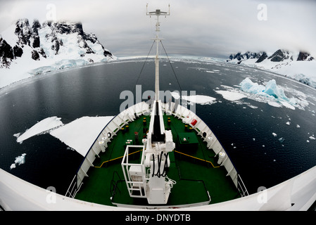 Antarktis - Ein Eis gestärkt Schiff treibt durch verstreute Platten von Meereis im ruhigen Wasser in der Lemaire Kanal auf der westlichen Seite der Antarktischen Halbinsel. Stockfoto