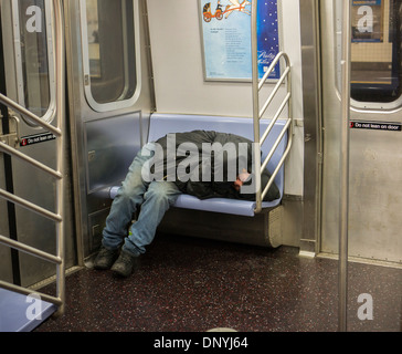 Obdachloser füllt mehrere Sitze, wie er in einer u-Bahn in New York auf Montag, 6. Januar 2014 schläft. (© Richard B. Levine) Stockfoto