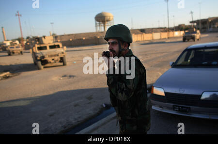 23. Februar 2006; AR-Ramadi, Anbar, Irak; Mitglied der irakischen Polizei Wolf-Brigade, 1. Bataillon, 506. Infanterieregiment befestigt, spricht 101st Airborne Division (Air Assualt) auf seinem Radio nach der Einnahme von Gewehrfeuer von Aufständischen.  Obligatorische Credit: Foto von Toby Morris/ZUMA Press. (©) Copyright 2006 von Toby Morris Stockfoto