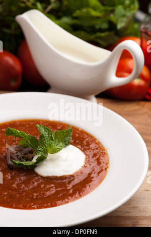 Schüssel mit gerösteten köstliche Tomatensuppe, garniert mit Kräutern und gerösteten Zwiebeln, serviert mit crème Stockfoto