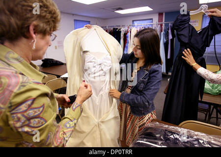 3. April 2006; West Palm Beach, FL, USA; Bonnie Weber, West Palm Beach, übergibt drei ihrer Tochter Kleider über Student Koordinator Joanna Suarez, 17, ein Senior an Dryfoos School of the Arts an der Prom Kleid Exchange Programm 2006 im Vickers-Haus in West Palm Beach Montag. Weber habe mich gefragt, was mit ihrer Tochter, Leann Davis, Kleider, die saßen in der Stockfoto