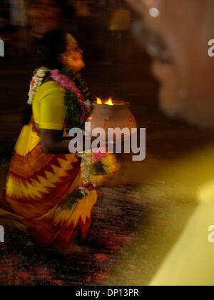 14. April 2006; Chennai, Tamil Nadu, Indien; Spirituelle Hindu Amman Anhänger laufen über glühende Kohlen mit Opfergaben an den Herrn Amman. Obligatorische Credit: Foto von Daniel Wilkinson/Daniel Wilkinson. (©) Copyright 2006 von Daniel Wilkinson Stockfoto