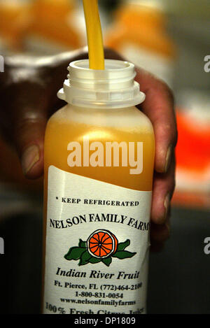 24. April 2006; Fort Pierce, FL, USA; Bei Nelson Family Farms, frisch gepressten Orangensaft hergestellt und abgefüllt in "The Juice Hütte"-eigentlich ein gekühlter Frachtcontainer in einer Miniatur-Saft-Anlage umgebaut wurde.  Im Gegensatz zu den meisten Saft, die pasteurisiert ist, bevor Sie verkauft werden, wird der Saft frisch gepressten verkauft. (nicht pasteurisiert)   Hier, "Saft Meister" Carl Buchholz Hand Stockfoto