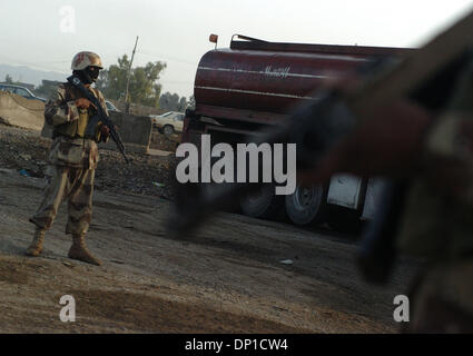 28. April 2006; Bayji, Saluhiddin, Irak; 19. April 2006-Datei Foto. Eine Junedi Uhren einen LKW-Fahrer eine Fach auf seinen LKW bei einer Durchsuchung einer Raststätte außerhalb des Bayji, Irak zu öffnen. Obligatorische Credit: Foto von Bill Putnam/ZUMA Press. (©) Copyright 2006 von Bill Putnam Stockfoto