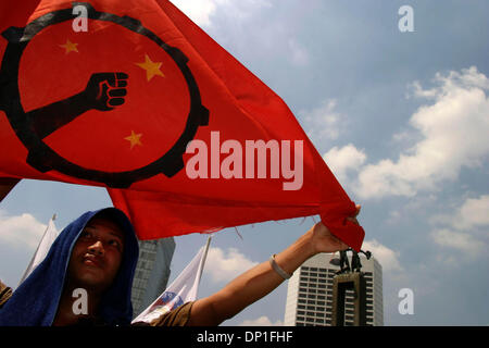 1. Mai 2006; Jakarta, Indonesien; Ein Arbeitnehmer führt eine rote Fahne, die spezifisch für einen bestimmten Arbeitnehmer-Union, während bei Hotel Indonesien protestieren. Tausende von Arbeitern aus verschiedenen Regionen sammelten für die Kennzeichnung der internationalen Arbeiter Tag Ð May Day. Neben Protest der Revisionen, Arbeitsrecht verlangen sie auch Regierung Maifeiertag als nationaler Feiertag zu erklären. Polizei bei der Demonstration kep Stockfoto