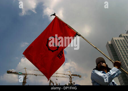 1. Mai 2006; Jakarta, Indonesien; Ein Arbeitnehmer führt eine rote Fahne, die spezifisch für einen bestimmten Arbeitnehmer-Union, während bei Hotel Indonesien protestieren. Tausende von Arbeitern aus verschiedenen Regionen sammelten für die Kennzeichnung der internationalen Arbeiter Tag Ð May Day. Neben Protest der Revisionen, Arbeitsrecht verlangen sie auch Regierung Maifeiertag als nationaler Feiertag zu erklären. Polizei bei der Demonstration kep Stockfoto