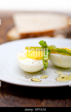 gekochter frischer grüner Spargel und Ei mit Olivenöl extra vergine mit Bauernbrot Stockfoto