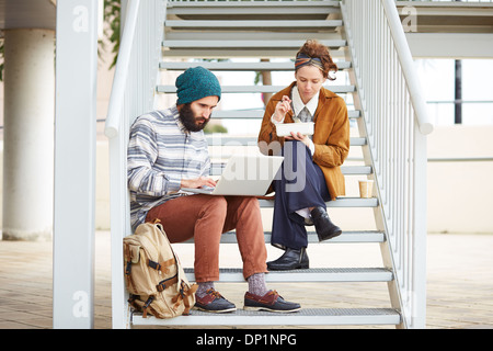 Hipster-paar mit Computer und sitzen in Treppe am Campus der Universität Essen Stockfoto