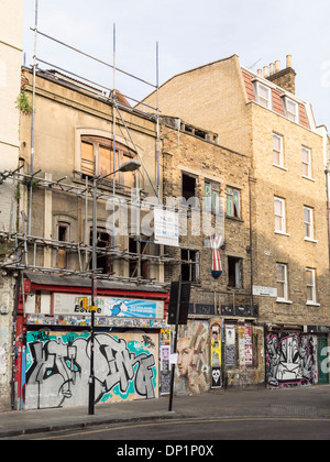 Verfallene Geschäfte bedeckt Graffiti in Redchurch Street, London, England Stockfoto