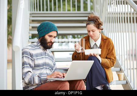 Hipster-paar mit Computer und sitzen in Treppe am Campus der Universität Essen Stockfoto