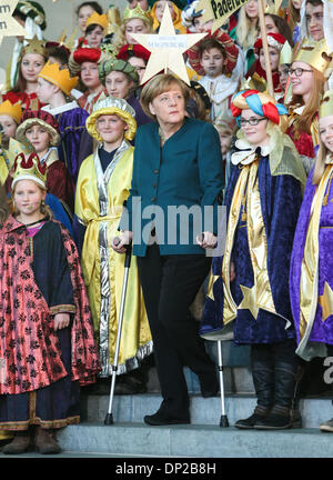 Berlin, Deutschland. 7. Januar 2014. German chancellor Angela Merkel (C) steht mit Krücken, wie sie einen Empfang mit jungen Sternsinger im Kanzleramt in Berlin, Hauptstadt der Bundesrepublik Deutschland, am 7. Januar 2014 besucht. Bundeskanzlerin Angela Merkel hat ihr Becken in einem Langlauf-Unfall in der Schweiz verletzt und müssen mehrere Besprechungen absagen, sagte ihr Sprecher Steffen Seibert am Montag. Bildnachweis: Zhang Fan/Xinhua/Alamy Live-Nachrichten Stockfoto