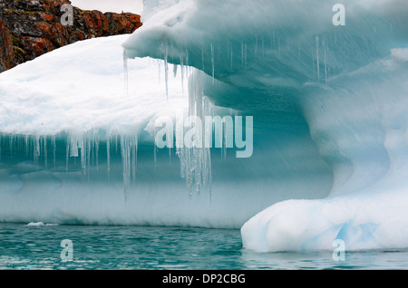 Antarktis - lange Eiszapfen hängen von der Kante eines Eisbergs in Cierva Cove in der Antarktis. Stockfoto