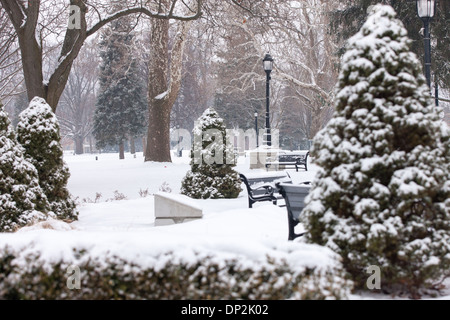 Den letzten Schneefall umfasst Bäume, Parkbänke und Trinkbrunnen im Victoria Park. Stockfoto