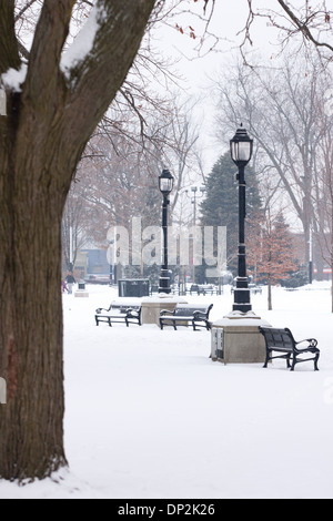 Den letzten Schneefall umfasst Bäume, Parkbänke und Trinkbrunnen im Victoria Park. Stockfoto